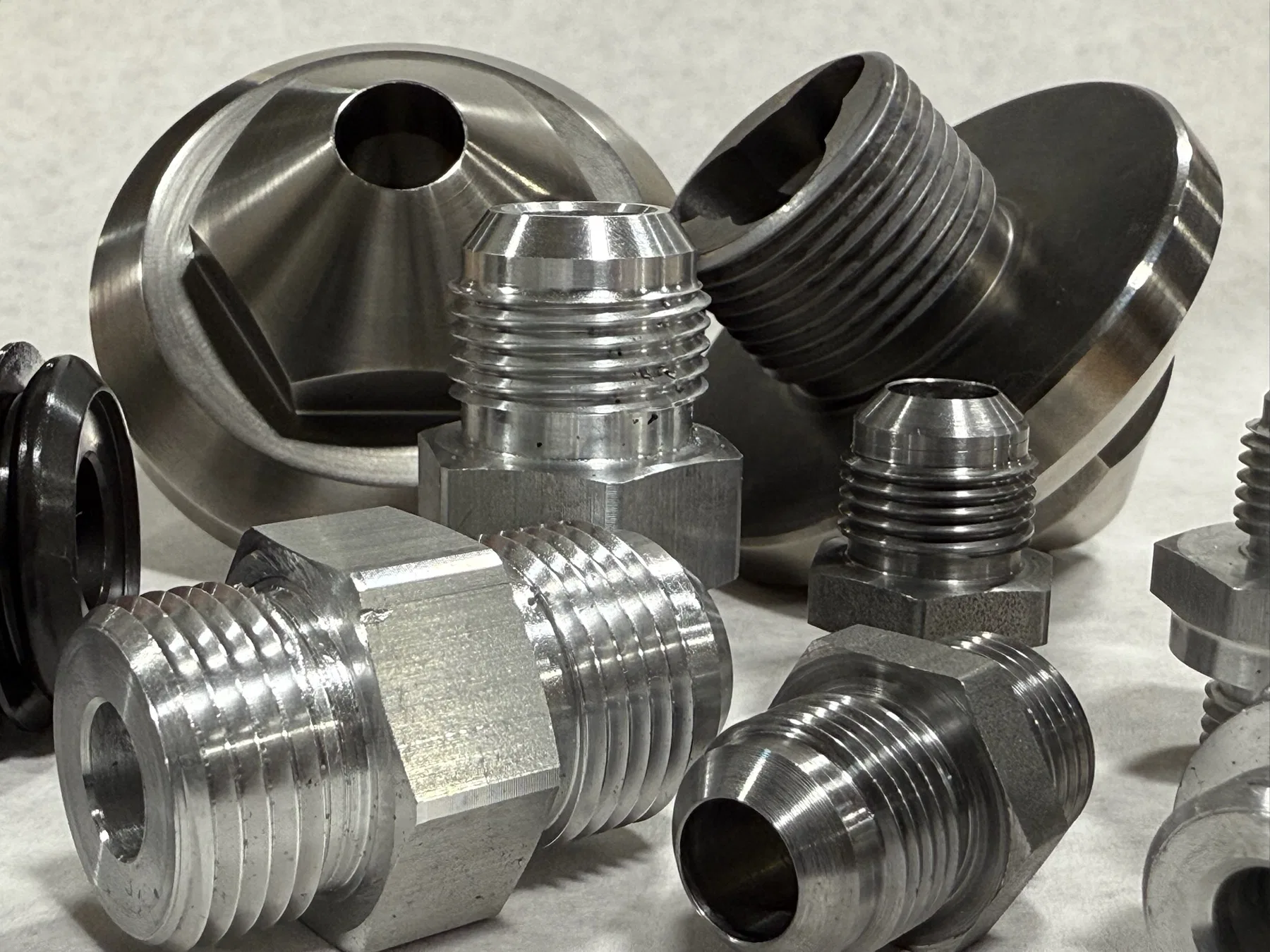 Close-up group of precision machined threaded components for CNC milling and component support.