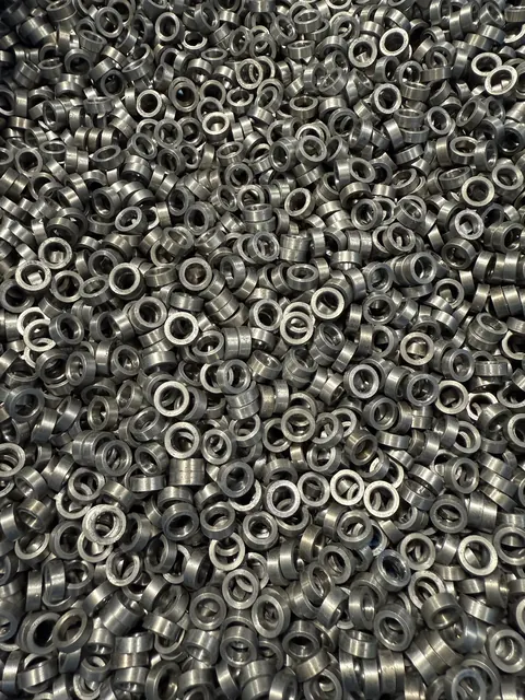 Large bin of small machined components.