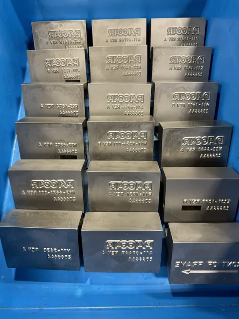 Stacked custom marking blocks prepared for production use.