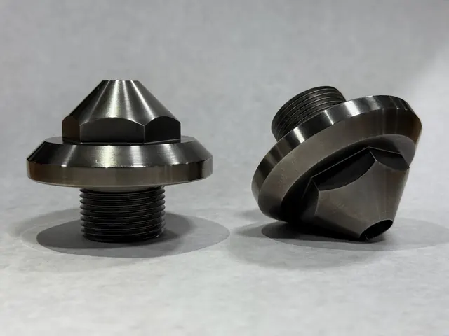 Two turned metal components with conical profiles.