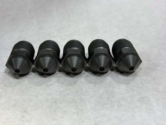 Row of small turned threaded components.