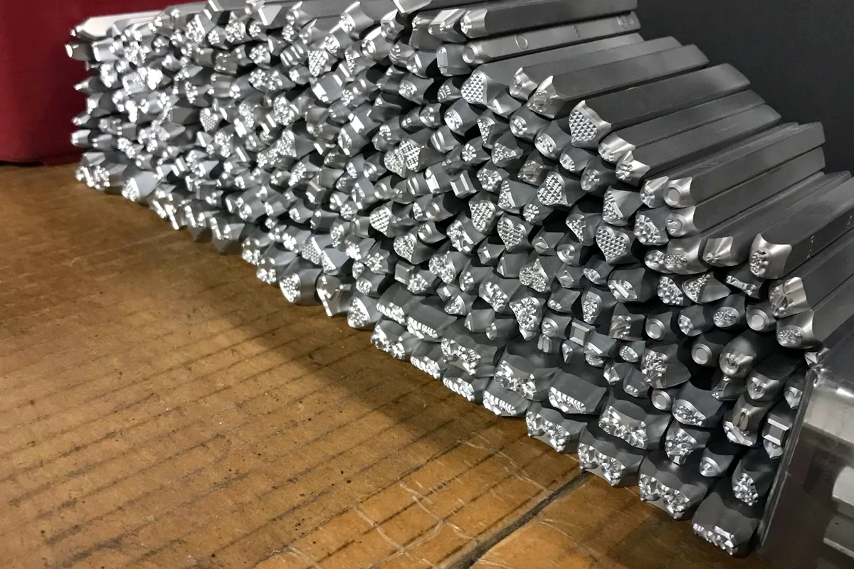 Finished steel hand stamps arranged in production quantity.